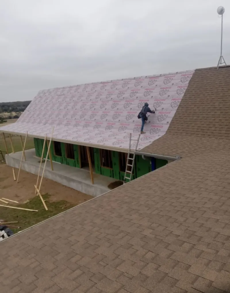 Worker preparing underlayment for a metal roof installation in Clermont